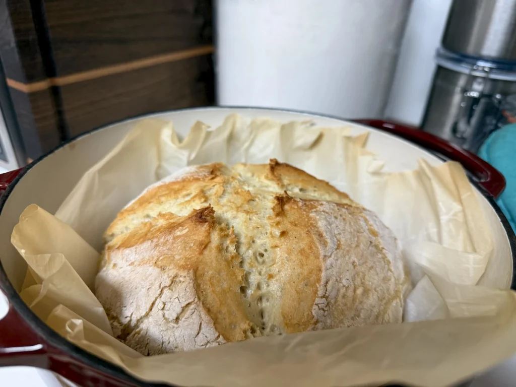 Fresh bread baked in a red Dutch oven during an ice storm
