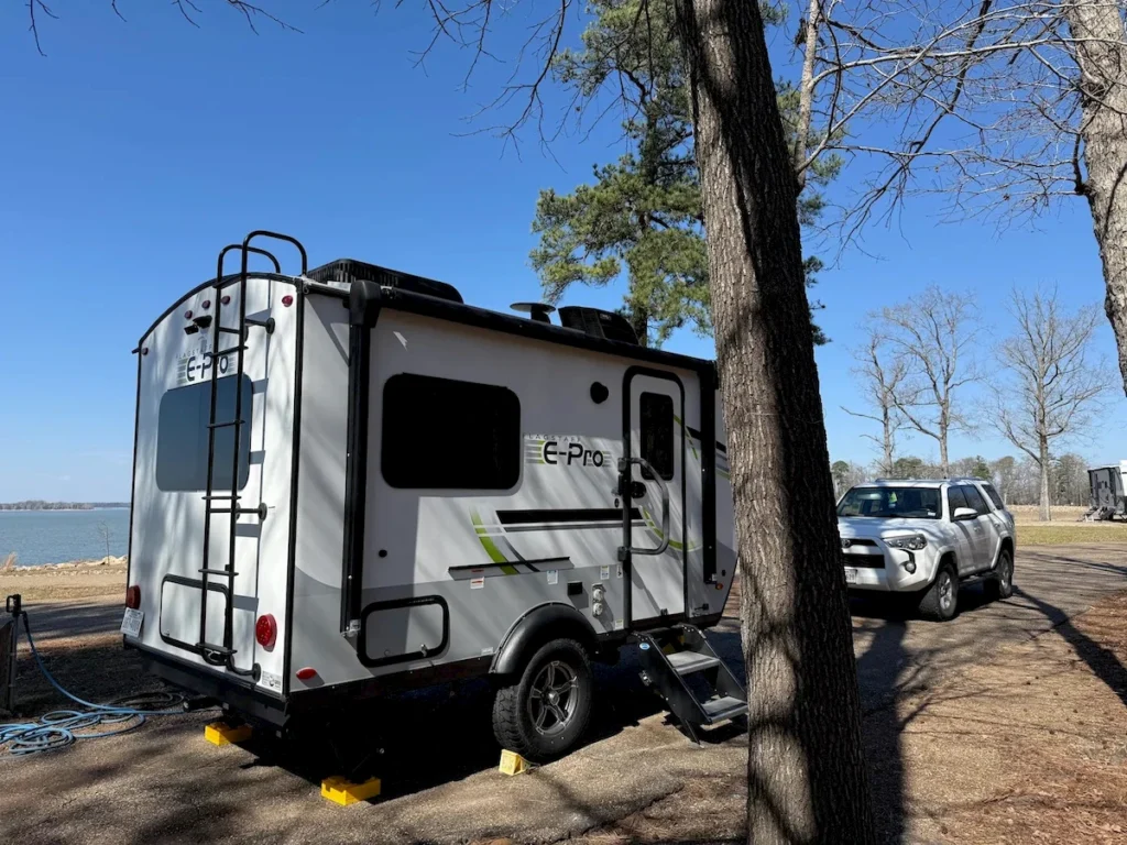 Flagstaff E-Pro camper and Toyota 4Runner parked under pine trees at Rocky Point Park