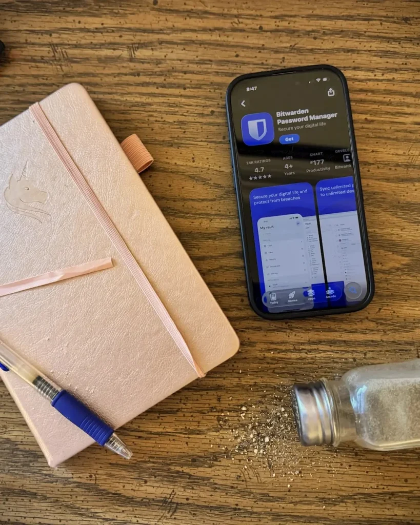 Bitwarden app on phone next to a notebook and spilled black pepper representing the pepper security method