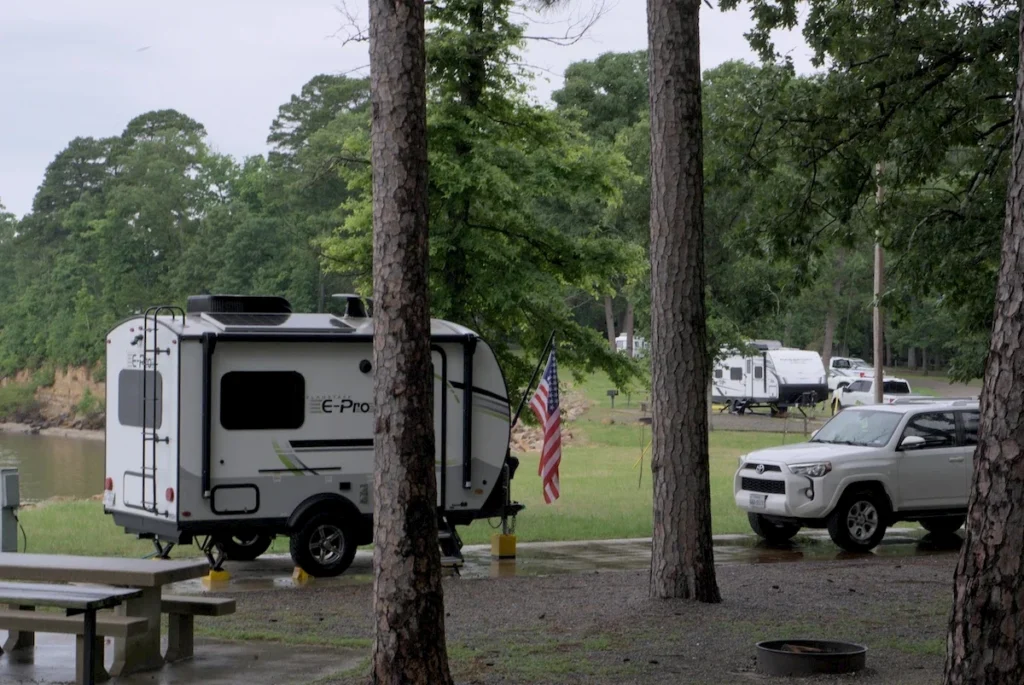 Our camper and 4Runner at a rainy campsite during our 2025 camping journey