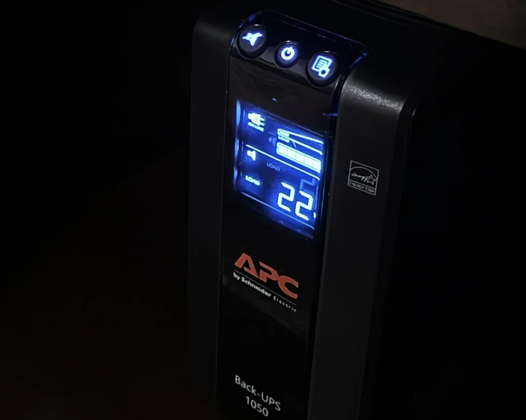 APC Back-UPS Pro BN1050M unit sitting on a shelf as part of a homelab power protection setup.